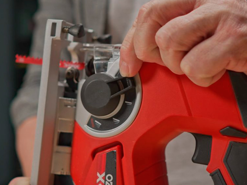 A man adjusts the depth of a jigsaw